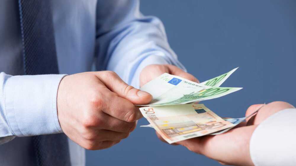 Businessman counting euro banknotes, blue background